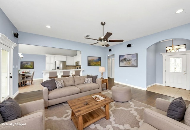 living room featuring recessed lighting, arched walkways, visible vents, and baseboards