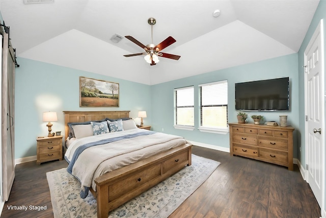 bedroom featuring a barn door, visible vents, dark wood-type flooring, and lofted ceiling