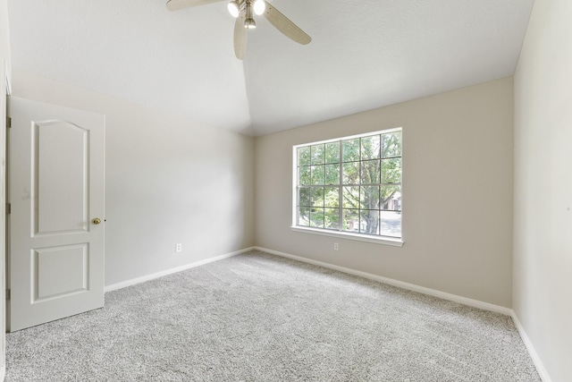 spare room featuring vaulted ceiling, baseboards, carpet floors, and ceiling fan