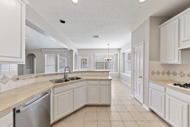 kitchen featuring light countertops, light tile patterned floors, stainless steel dishwasher, white cabinetry, and a sink