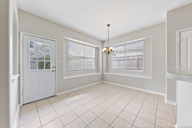 unfurnished dining area with baseboards, a chandelier, and light tile patterned flooring