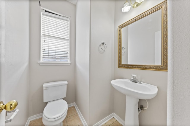 bathroom featuring tile patterned flooring, toilet, and baseboards