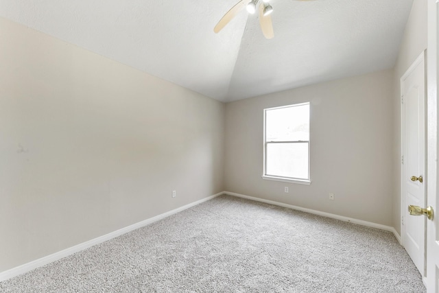 spare room featuring light carpet, baseboards, lofted ceiling, and ceiling fan