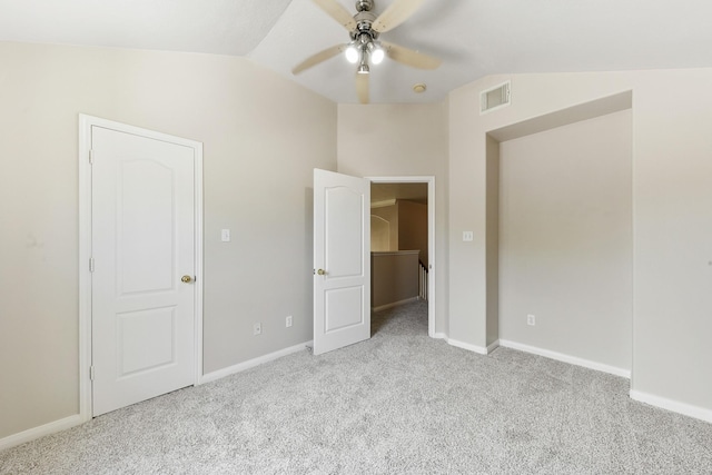 unfurnished bedroom featuring a spacious closet, visible vents, baseboards, vaulted ceiling, and carpet flooring