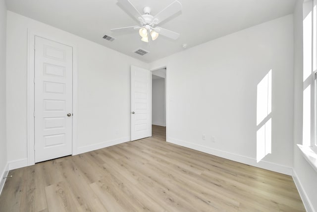 unfurnished bedroom with light wood-style flooring, baseboards, visible vents, and ceiling fan