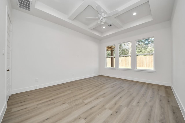 empty room with light wood finished floors, visible vents, baseboards, beamed ceiling, and coffered ceiling