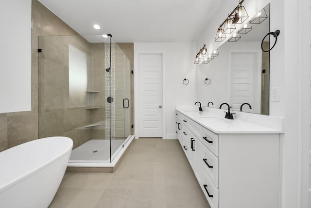 bathroom featuring double vanity, a freestanding tub, a stall shower, and a sink