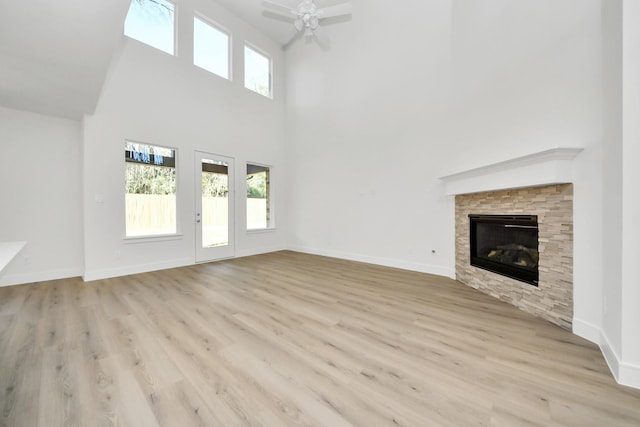 unfurnished living room featuring ceiling fan, baseboards, and wood finished floors