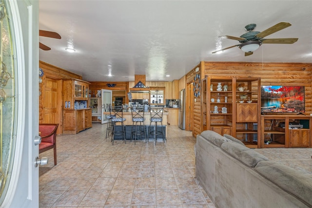 living room featuring log walls and a ceiling fan