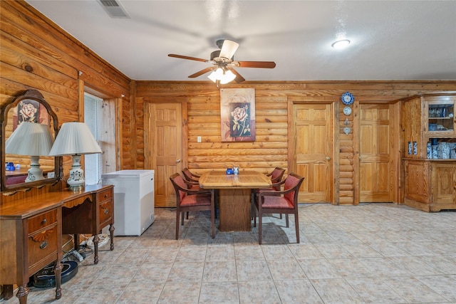 dining space with a ceiling fan, visible vents, and rustic walls