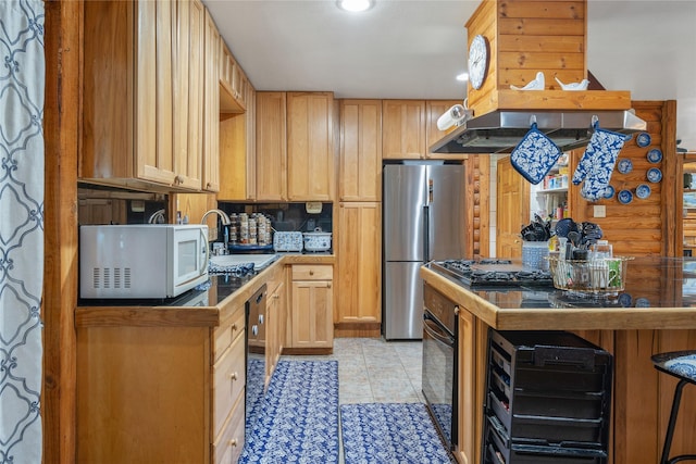 kitchen with light tile patterned floors, white microwave, freestanding refrigerator, oven, and a sink