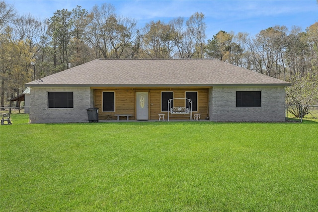 ranch-style house with a shingled roof and a front lawn