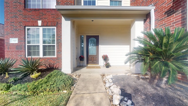 view of exterior entry featuring brick siding