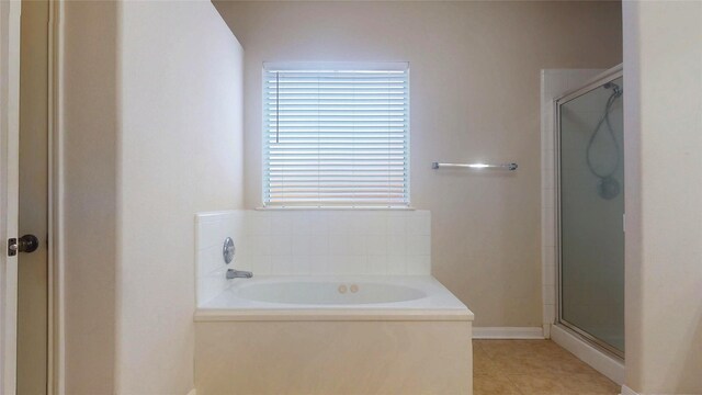 full bathroom with a shower stall, a bath, and tile patterned floors