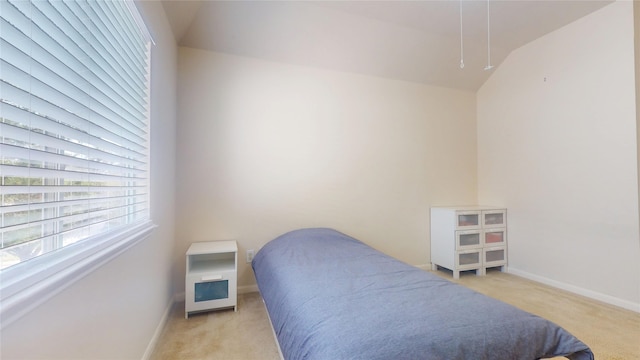 bedroom with light colored carpet and baseboards