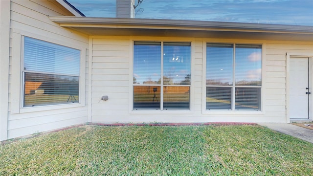 view of exterior entry featuring a yard