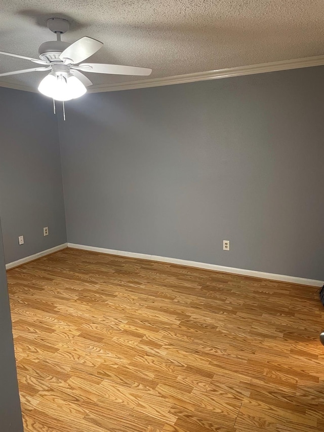 empty room with a textured ceiling, ornamental molding, a ceiling fan, and light wood finished floors