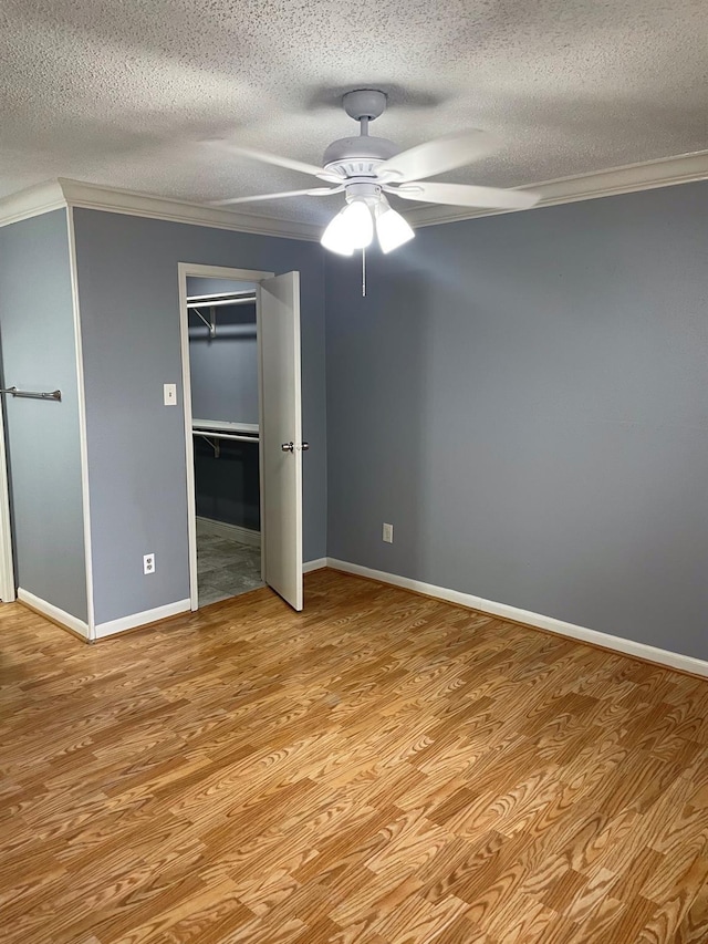 unfurnished bedroom with baseboards, wood finished floors, and ornamental molding