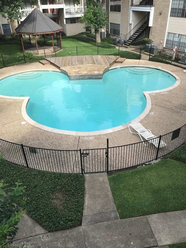 pool with a gazebo, a yard, and fence