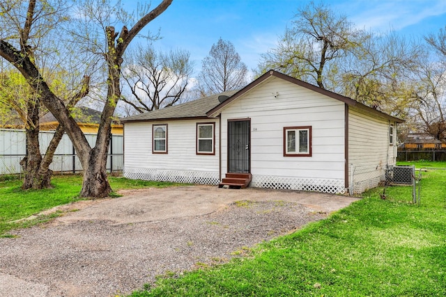 view of front facade with entry steps, central AC, a front yard, and fence