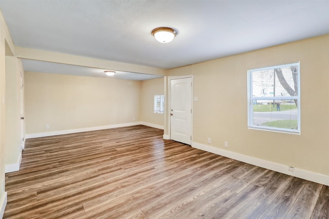 empty room with baseboards and wood finished floors