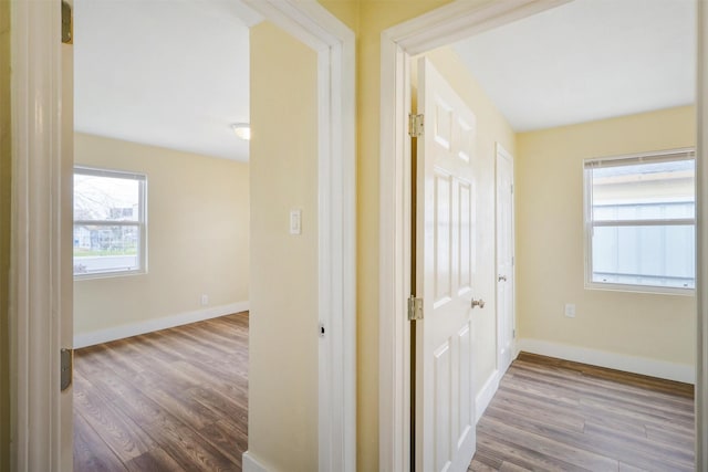 corridor with wood finished floors and baseboards