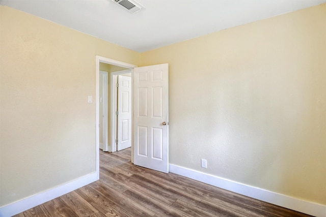 empty room with visible vents, baseboards, and wood finished floors