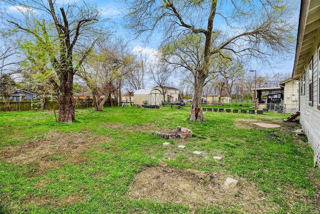 view of yard featuring an outbuilding, a fenced backyard, and a storage shed