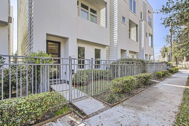 exterior space featuring stucco siding and fence