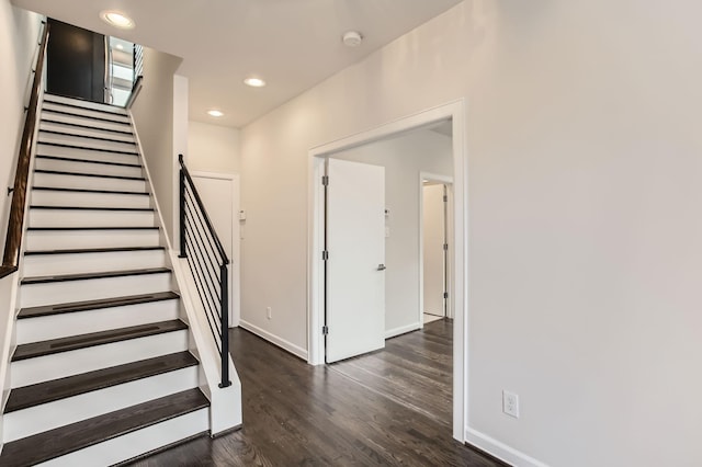 stairway featuring recessed lighting, wood finished floors, and baseboards