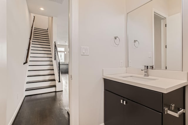 bathroom with vanity, recessed lighting, wood finished floors, and baseboards