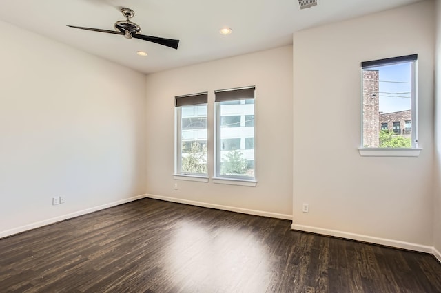 spare room featuring a ceiling fan, plenty of natural light, wood finished floors, and baseboards