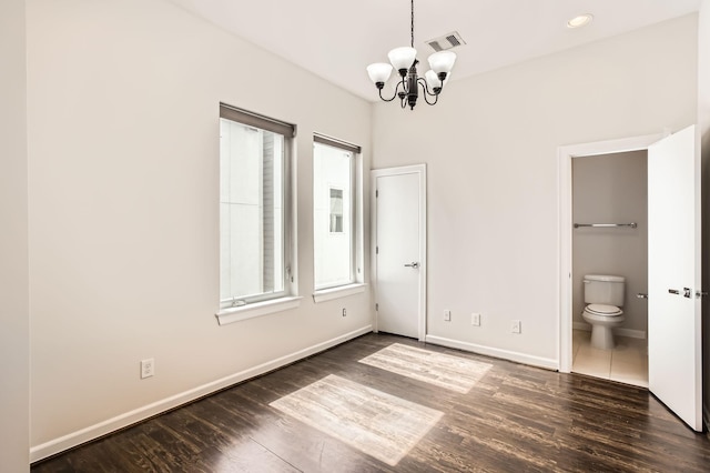 126 Pierce St, Houston, TX 77002 - unfurnished bedroom with a chandelier, ensuite bath, baseboards, visible vents, and dark wood-style flooring