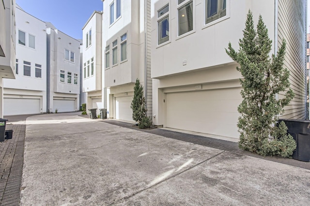 exterior space with stucco siding, a residential view, and an attached garage