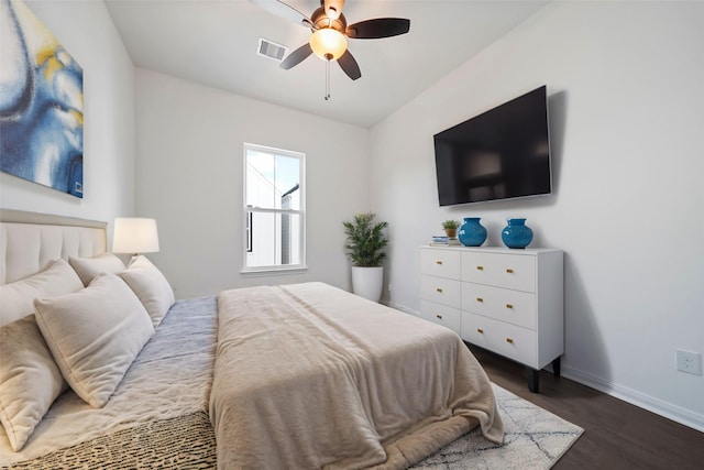 bedroom featuring visible vents, baseboards, dark wood-type flooring, and a ceiling fan