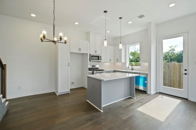 kitchen featuring visible vents, a notable chandelier, a sink, white cabinetry, and appliances with stainless steel finishes