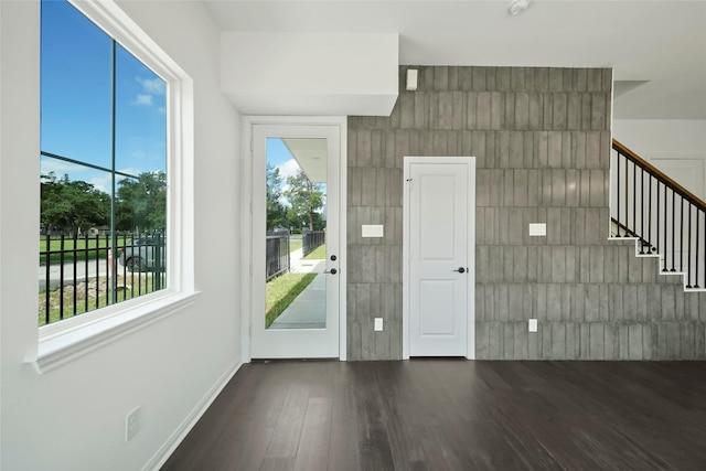 interior space with stairway, baseboards, and wood finished floors