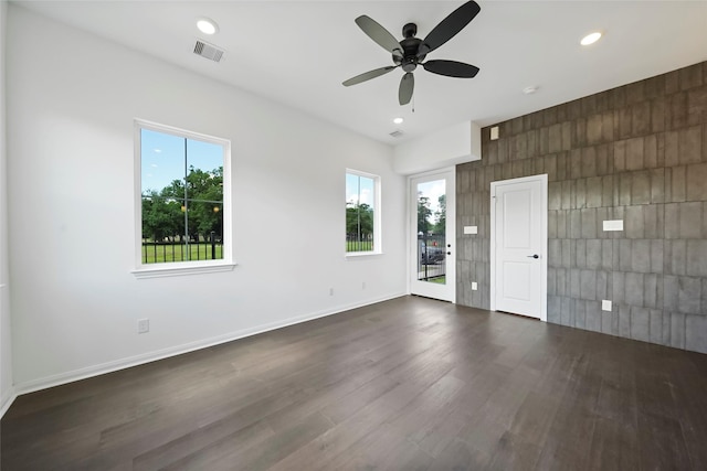 empty room with visible vents, recessed lighting, baseboards, ceiling fan, and dark wood-style flooring