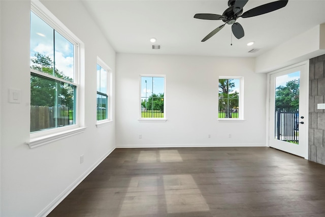 unfurnished room featuring visible vents, baseboards, dark wood-type flooring, and ceiling fan