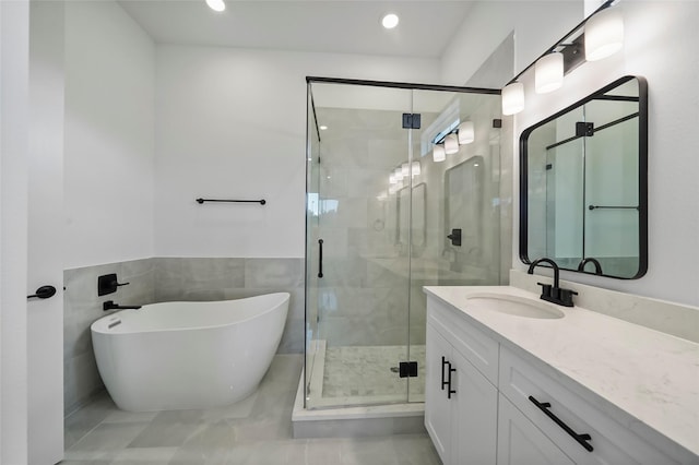 bathroom with vanity, a freestanding tub, recessed lighting, and a stall shower