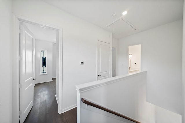 hall with an upstairs landing, dark wood finished floors, recessed lighting, baseboards, and attic access