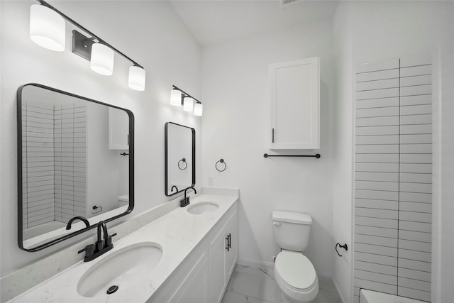 bathroom featuring a sink, baseboards, toilet, and marble finish floor