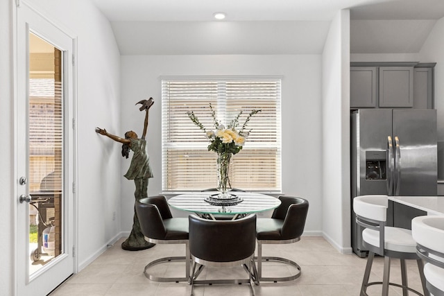 dining space featuring light tile patterned floors, baseboards, and plenty of natural light