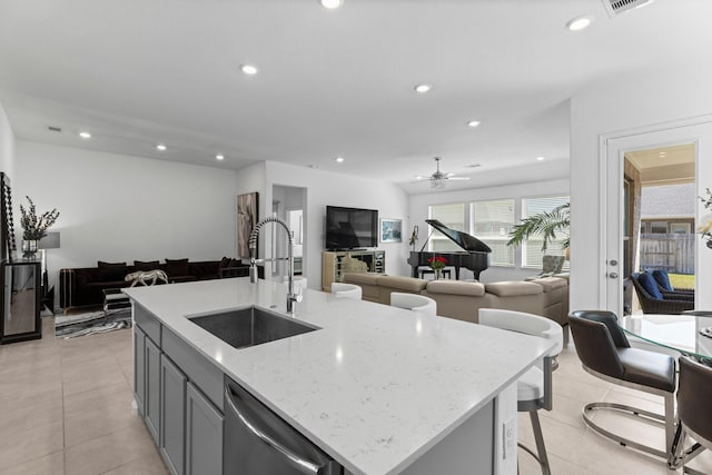 kitchen with a sink, stainless steel dishwasher, open floor plan, and recessed lighting