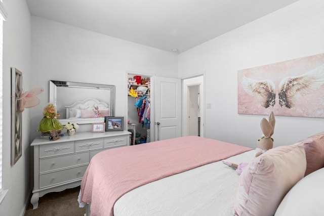 bedroom featuring a spacious closet, dark carpet, and a closet