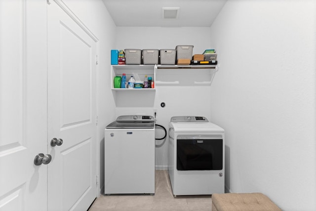 laundry area featuring laundry area, light tile patterned floors, separate washer and dryer, and visible vents