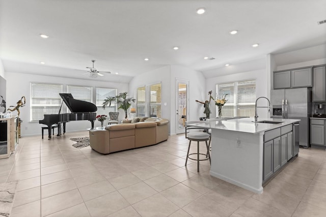 kitchen featuring a ceiling fan, light tile patterned flooring, a sink, gray cabinetry, and open floor plan