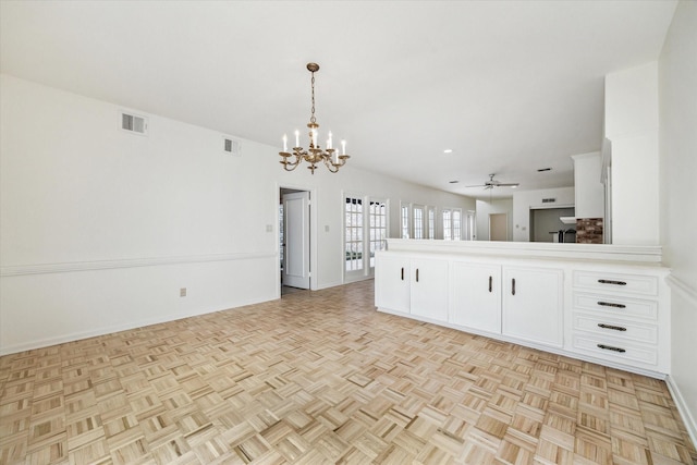 kitchen with open floor plan, white cabinets, ceiling fan with notable chandelier, and visible vents