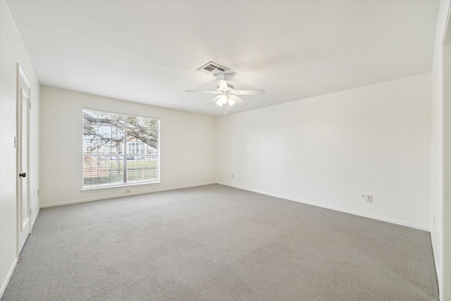 spare room with carpet flooring, visible vents, baseboards, and a ceiling fan