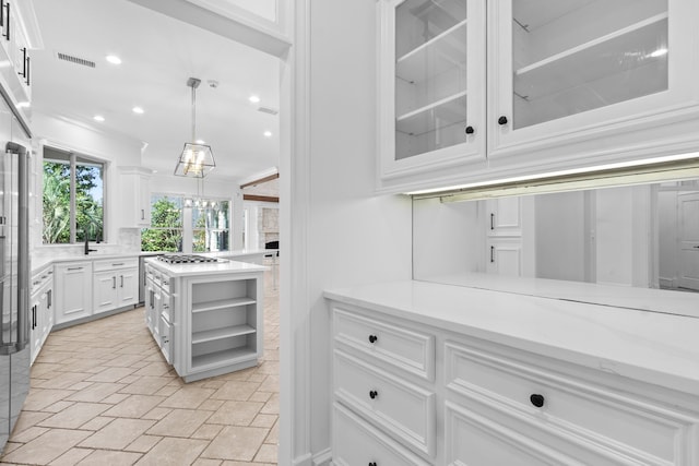 kitchen featuring visible vents, glass insert cabinets, ornamental molding, white cabinetry, and open shelves